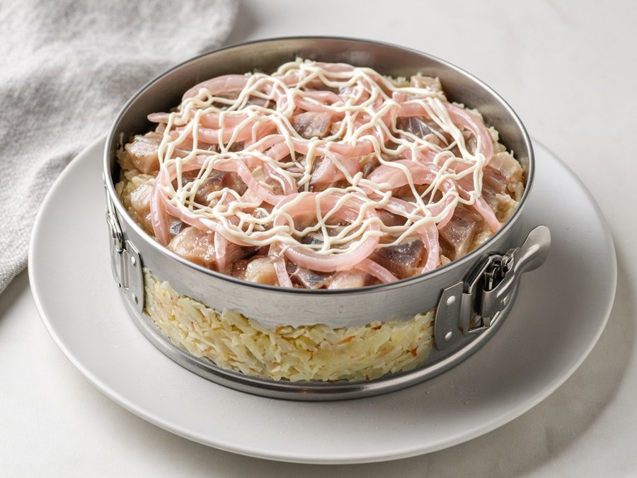 Слой селёдки и маринованного лука на картофеле